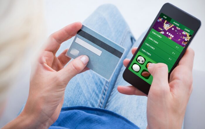 Una persona realizando una apuesta online con una tarjeta de crédito