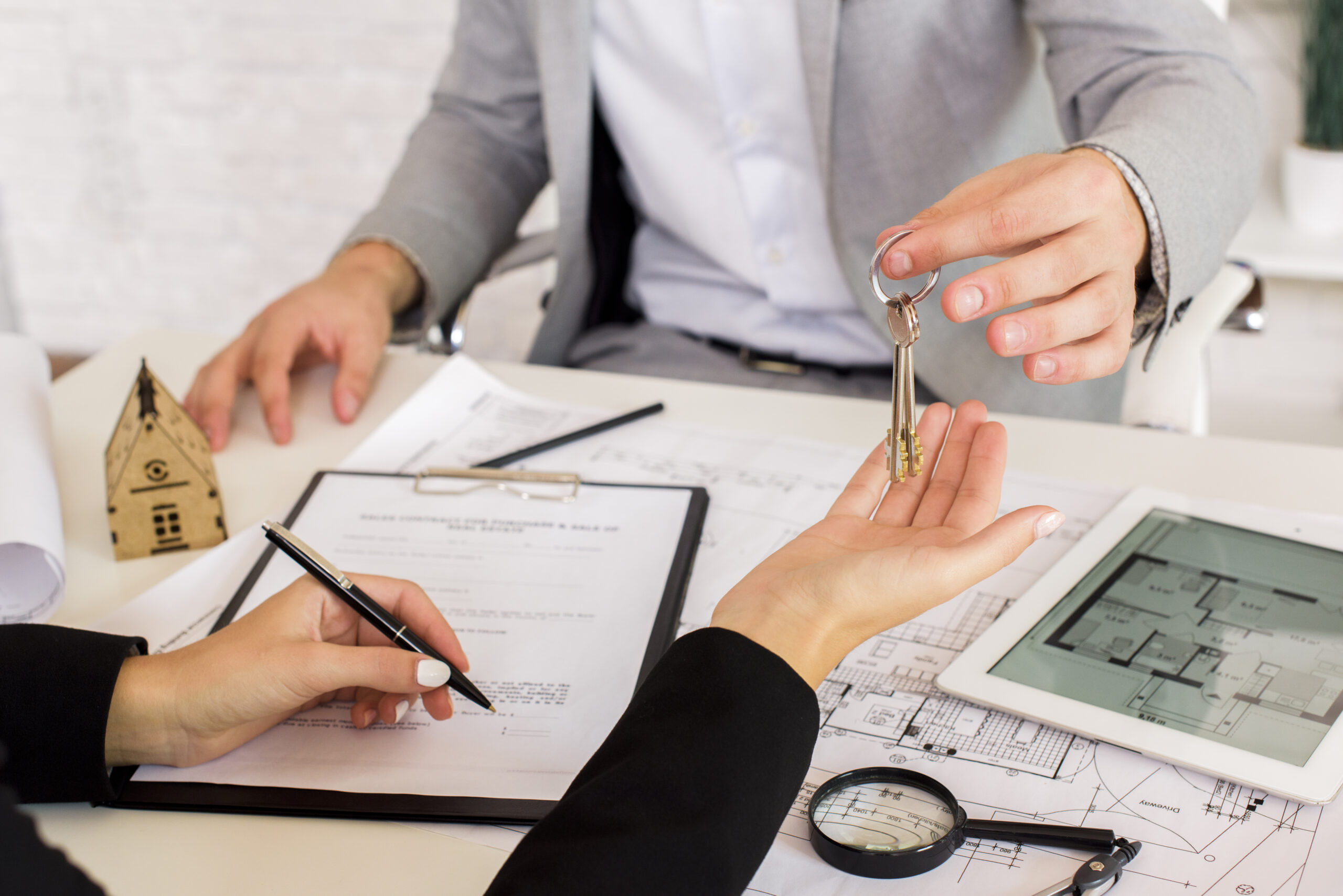 Agente entregando llaves durante firma de contrato de inversión inmobiliaria en Miami